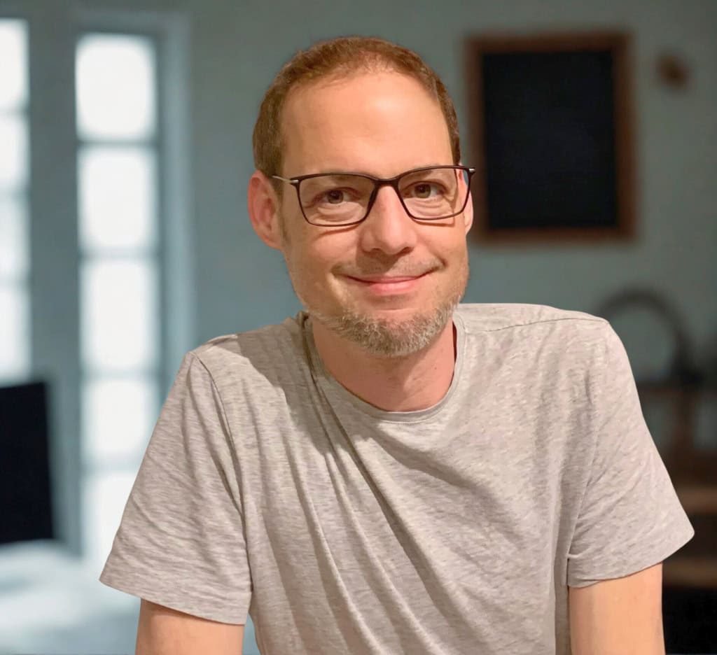 Porträtfoto von Markus, der lächelnd in die Kamera blickt.